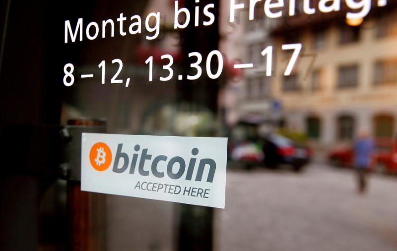 FILE PHOTO: FILE PHOTO: A sticker that reads "Bitcoin accepted here" is displayed at the entrance of the Stadthaus town hall in Zug, Switzerland, August 30, 2016. REUTERS/Arnd Wiegmann/File Photo